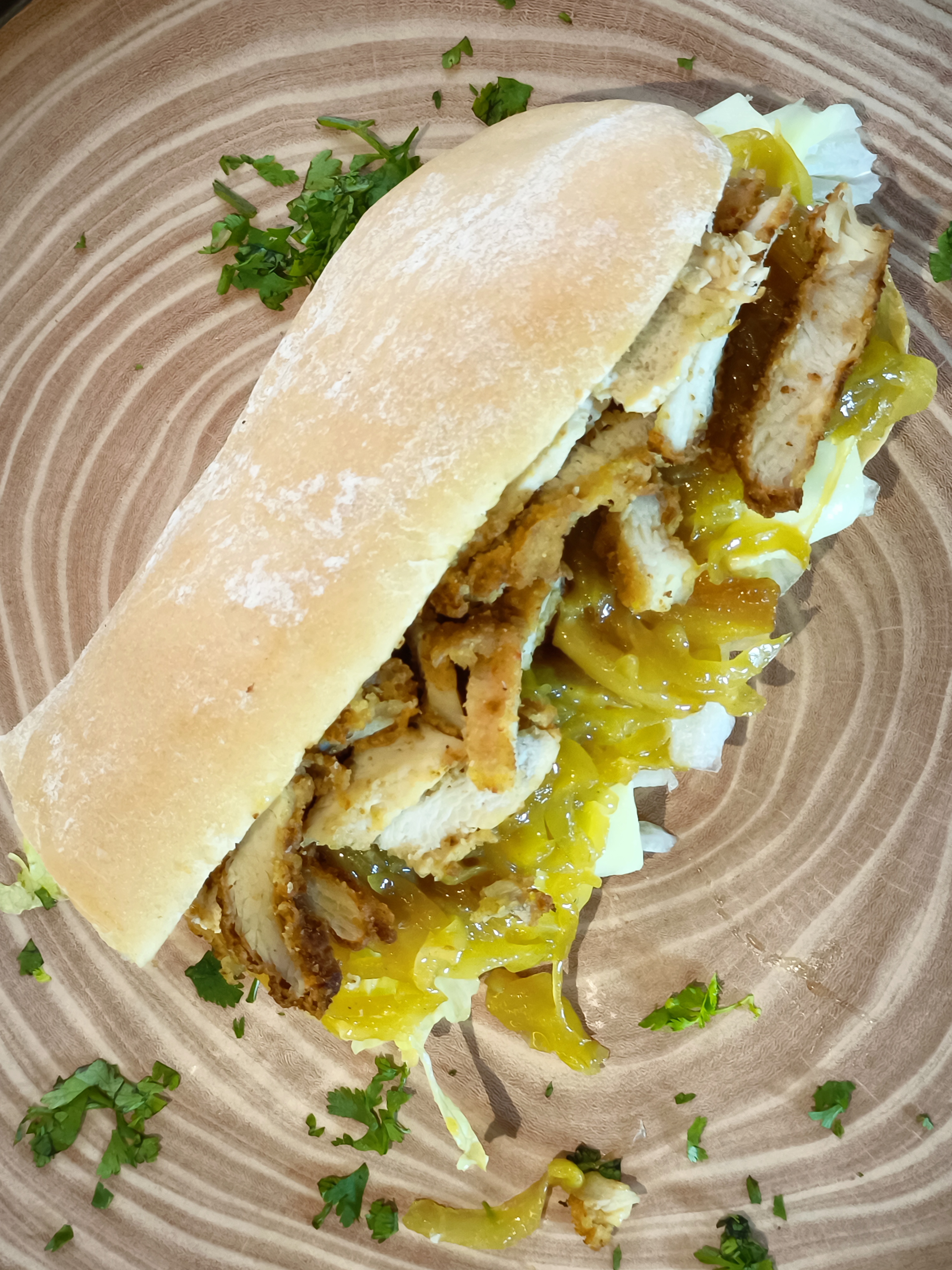 Sándwich de filete de pollo apanado con cebolla caramelizada